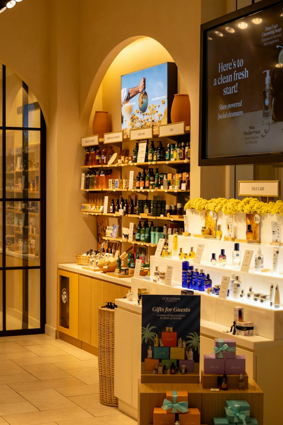 Prodotti per la cura della pelle disposti sugli scaffali all'interno di un negozio L'Occitane.